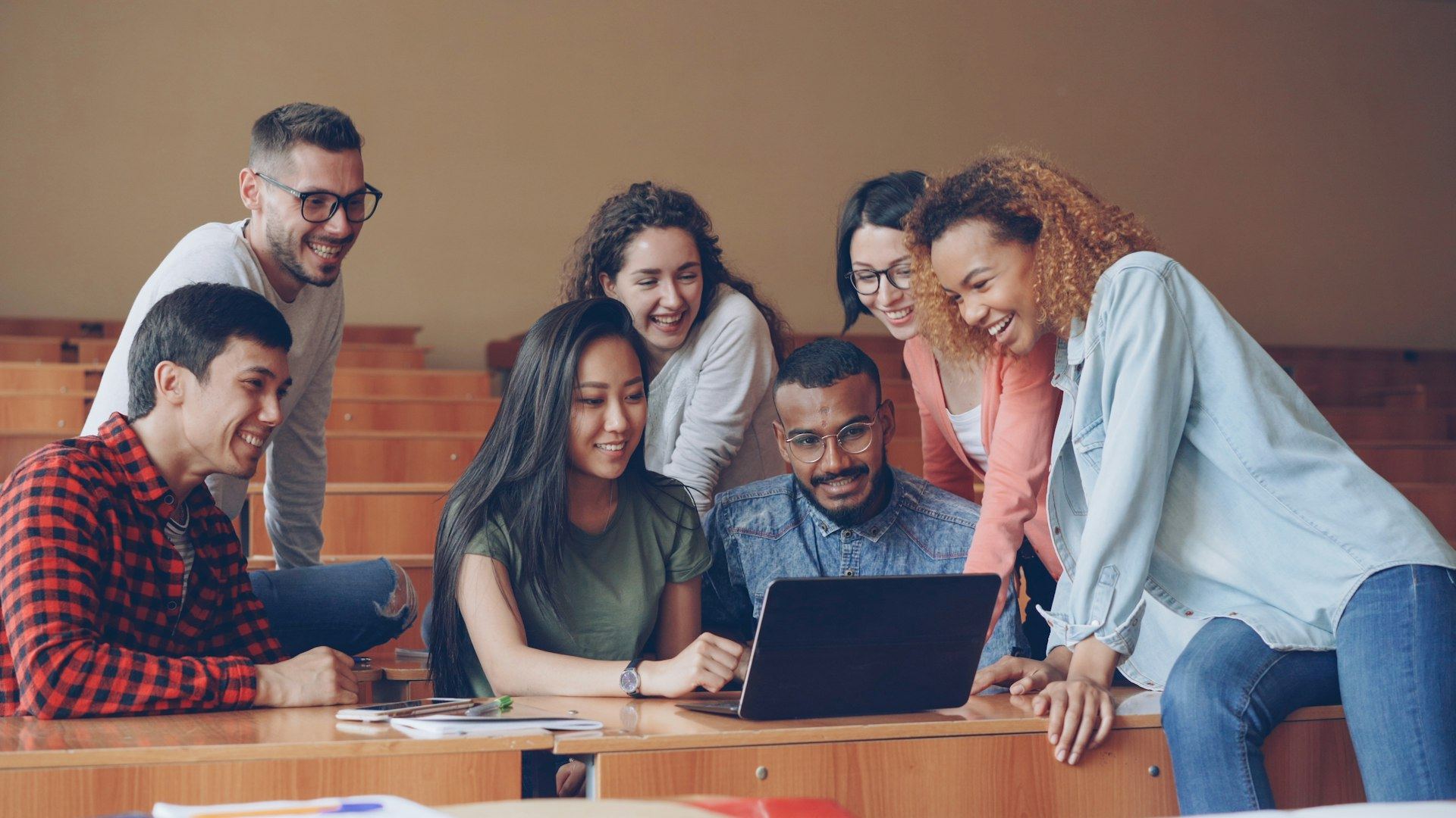 A group of young professionals working together around a laptop